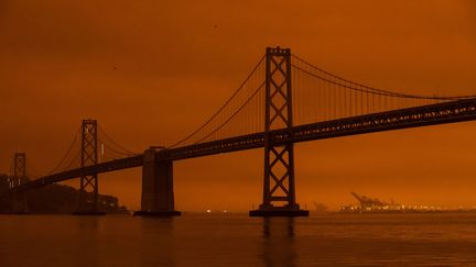 Le célèbre Bay Bridge de San Francisco se détache sur le ciel orangé,&nbsp;coloré&nbsp;par la fumée des incendies qui ravagent des forêts plus au nord, le 9 septembre 2020.&nbsp; (PHILIP PACHECO / GETTY IMAGES NORTH AMERICA / AFP)