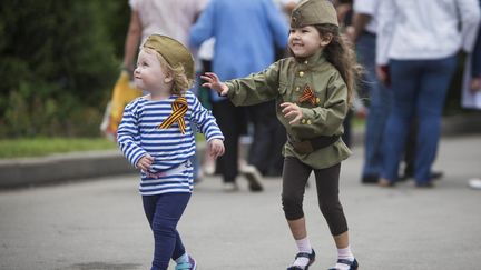 Deux petites filles portant le calot de l'armée rouge et arborant le ruban de Saint-Georges, symbole de la victoire, se baladent à Almaty, au Kazakhstan. (REUTEURS - SHAMIL ZHUMATOV)