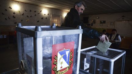 Un habitant de Crim&eacute;e vote lors du r&eacute;f&eacute;rendum pour le rattachement de la p&eacute;ninsule &agrave; la Russie, le 16 mars 2014 dans le village de&nbsp;Shirokoye. (VALERIY MELNIKOV / RIA NOVOSTI / AFP)