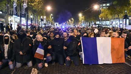 Des policiers s'assoient en plein milieu des Champs-Elysées pour manifester le 20 octobre 2016. (BERTRAND GUAY / AFP)