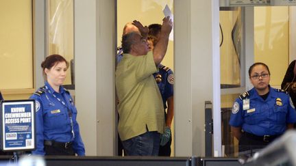 Un voyageur et deux agents de l'agence de s&eacute;curit&eacute; des transports, le 2 novembre 2013, &agrave; Los Angeles. (KEVORK DJANSEZIAN / GETTY IMAGES NORTH AMERICA)