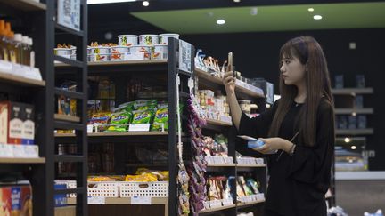 Une consommatrice scanne un produit pour le payer dans un magasin à Hangzhou (NI YANQIANG / IMAGINECHINA)