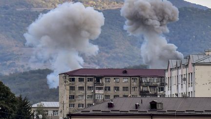 De la fumée s'élève après le bombardement de Stepanakert, le 9 octobre 2020, lors des combats entre l'Arménie et l'Azerbaïdjan sur la région contestée du Haut-Karabakh.&nbsp; (ARIS MESSINIS / AFP)