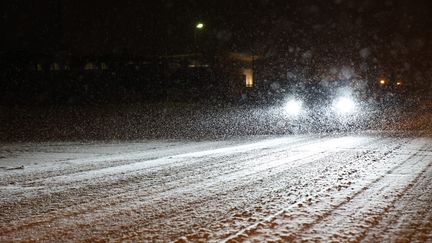 Une voiture circule sur une route enneigée à Soultz-Haut-Rhin (Haut-Rhin), le 9 janvier 2024. (SAMUEL COULON / MAXPPP)