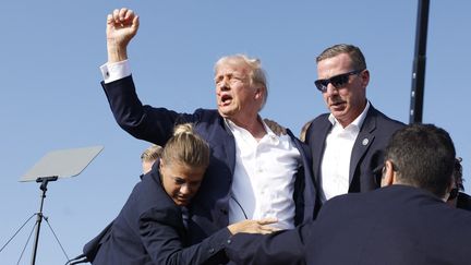 Donald Trump, juste après avoir été victime d'une tentative d'assassinat, le 13 juillet 2024, lors d'un meeting à Butler, en Pennsylvanie (États-Unis). (ANNA MONEYMAKER / GETTY IMAGES AMÉRIQUE DU NORD / AFP)