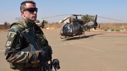 Un soldat fran&ccedil;ais pose &agrave; c&ocirc;t&eacute; d'un h&eacute;licopt&egrave;re Gazelle pr&egrave;s de Bamako (Mali), le 19 janvier 2013. (ERIC FEFERBERG / AFP)