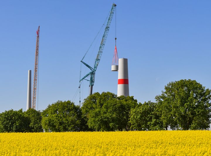 Un morceau d'acier est ajouté lors de la construction d'une éolienne, à&nbsp;Mallnow (Allemagne) le 7 mai 2018. (PATRICK PLEUL / DPA-ZENTRALBILD / AFP)