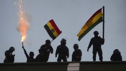 Des policiers opposés à la réélection d'Evo Morales lèvent un drapeau bolivien à Cochabamba, le 8 novembre 2019. (AP/SIPA)