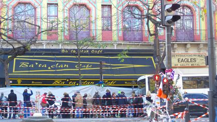 Deux semaines après les attentats du 13 novembre 2015 au Bataclan, les Parisiens ont laissé bougies, messages, photos en hommage aux victimes. Des parisiens devant le Bataclan, baché. (RADIO FRANCE / OLIVIER BÉNIS)