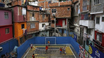 Des jeunes jouent au football dans une favela de Rio de Janeira (Br&eacute;sil), le 18 mai 2014. (PILAR OLIVARES / REUTERS)