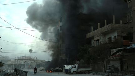 De la fumée s'échappe d'un immeuble bombardé dans la Ghouta orientale, en Syrie, le 10 mars 2018.&nbsp; (HAMZA AL-AJWEH / AFP)