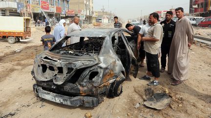 Une carcasse de&nbsp;voiture à&nbsp;Hosseiniyah, dans la périphérie de Bagdad (Irak), le 6 octobre 2015. (SABAH ARAR / AFP)