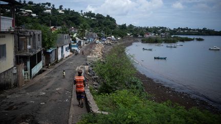 Un homme marche à Mamoudzou, sur l'île française de Mayotte, le 19 février 2024. (JULIEN DE ROSA / AFP)