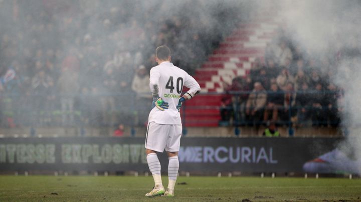 Le gardien du RC Lens Valentin Belon au milieu des fumig&egrave;nes, lors du match Caen-Lens, le 21 f&eacute;vrier 2015. (CHARLY TRIBALLEAU / AFP)