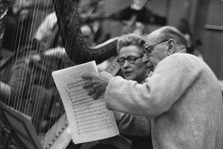 Le compositeur, chef d'orchestre, pianiste et écrivain d'origine russe Igor Fiodorovitch Stravinsky (1882 - 1971) étudie une partition avec Sidonie Goossens, harpiste principale du BBC Symphony Orchestra, lors d'une session d'enregistrement au studio Maida Vale en 1958. (ERICH AUERBACH / HULTON ARCHIVE)