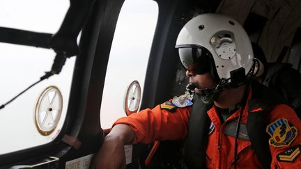 Un membre des forces a&eacute;riennes indon&eacute;siennes le 5 janvier 2015, durant les op&eacute;rations de recherche du vol QZ8501 d'AirAsia, disparu en mer de Java. (TATAN SYUFLANA / AFP)