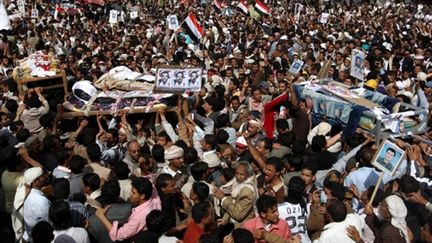 Hommage, le 20 mars 2011, de milliers de manifestants yéménites aux 52 tués du 18 mars, à Sanaa. (AFP/AHMAD GHARABLI)