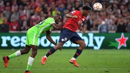 Jonathan David prend le meilleur sur Josuha Guilavogui lors du match entre Lille et Wolfsburg, le 14 septembre 2021. (DENIS CHARLET / AFP)