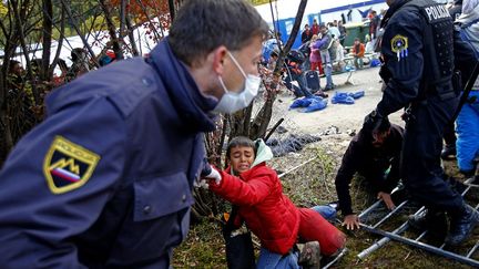 un policier vient au secours d'un enfant migrant menacé d'écrasement par la foule qui tentait de forcer un barrage pour passer la frontière avec l'Autriche. Ljubljana reproche à Vienne de n'accueillir les réfugiés qu'au compte-gouttes tandis que Zagreb est critiquée par le gouvernement slovène pour son «absence de communication et de coopération». «La Croatie ne respecte pas les accords concernant les passages de frontière et le nombre de réfugiés qui doivent entrer en Slovénie», a regretté le Premier ministre slovène Miro Cerar, dans un entretien au quotidien allemand «Die Welt». La Slovénie estime que près de 19.500 migrants sont entrés sur son territoire en quatre jours, entre le 16 et le 20 octobre. M. Cerar a rappelé la nécessité de créer des centres d'accueil européens aux frontières extérieures de l'UE.

	   (Leonhard FOEGER/ REUTERS)