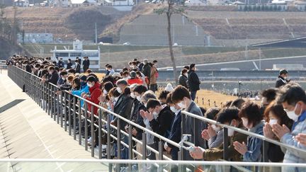 Des Japonais réunis le 11 mars 2021 à&nbsp;Rikuzen-Takata, ville côtière du nord-est du Japon, pour rendre hommage au victimes de la triple catastrophe du 11 mars 2011. (TETSU JOKO / YOMIURI / AFP)