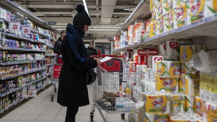 Une cliente dans un rayon de supermarché Auchan, à Paris, le 4 mars 2023. (SERGE TENANI / HANS LUCAS / AFP)