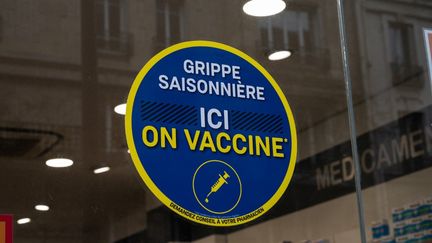 Une affiche pour le vaccin contre la grippe saisonnière sur la vitrine d'une pharmacie, à Paris, le 20 janvier 2021.&nbsp; (RICCARDO MILANI / HANS LUCAS / AFP)