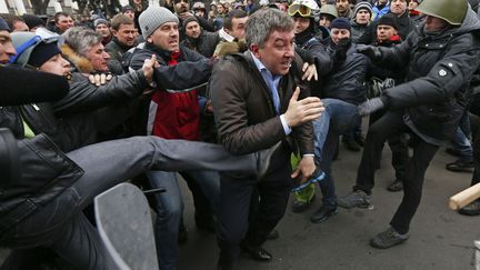 Des manifestants pro europ&eacute;ens attaquent le d&eacute;put&eacute;&nbsp;Vitaly Grushevsky (Parti des r&eacute;gions) devant le parlement ukrainien &agrave; Kiev (Ukraine), le 22 f&eacute;vrier 2014. ( VASILY FEDOSENKO / REUTERS)