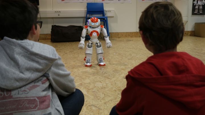 Mathieu et Ludovic, venus avec leurs grands-parents, observent avec attention le robot Nao en train de bouger. Cit&eacute; des sciences (Paris), mai 2015. (VALENTINE PASQUENOONE / FRANCE 2)