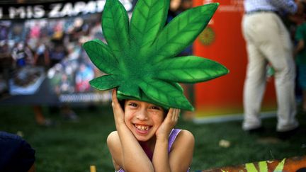 Un enfant porte un chapeau en forme de feuille de cannabis pendant une manifestation demandant la l&eacute;galisation th&eacute;rapeutique de la marijuana &agrave; Santiago (Chili), le 18 mars 2015. (IVAN ALVARADO / REUTERS)