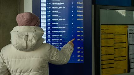 Une personne se tient devant un panneau d'information dans une gare de Limbourg (Allemagne), alors que de nombreux trains sont annulés suite à une grève, le mercredi 10 janvier. (IMAGO/ONEMOREPICTURE / THORSTEN WAGNER / MAXPPP)