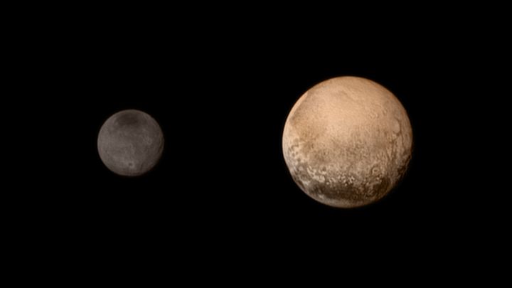 Charon (&agrave; gauche), la lune de Pluton, photographi&eacute; par la sonde New Horizons, le 11 juillet 2015. (NASA / GETTY IMAGES NORTH AMERICA / AFP)