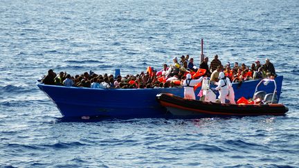 Une &eacute;quipe du Migrant Offshore Aid Station (MOAS) secourt une embarcation de migrants en M&eacute;diterran&eacute;e, le 8 septembre 2014. (AFP PHOTO / MOAS / HO)