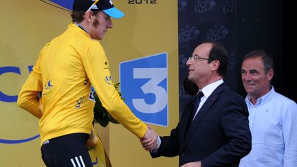 Nouvelle pr&eacute;sidence oblige, Fran&ccedil;ois Hollande s'est rendu sur le Tour en 2012 afin de saluer le leader britannique Bradley Wiggings, sous le regard de l'ancien coureur Bernard Hinault. (PASCAL PAVANI / AFP)