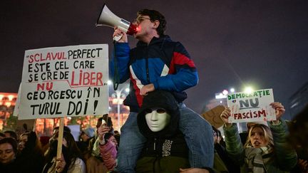 Des manifestants devant le palais du Parlement sur la place de la Victoire à Bucarest, en Roumanie, le 27 novembre 2024. (DANIEL MIHAILESCU / AFP)