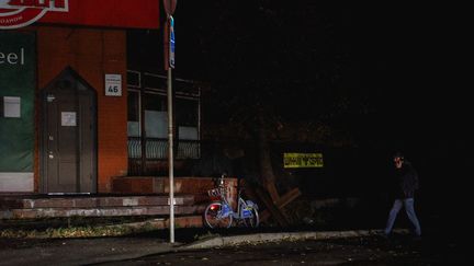 Un homme marche dans les rues de Kiev (Ukraine), privées d'électricité, le 2 novembre 2022. (SERGII KHARCHENKO / NURPHOTO / AFP)