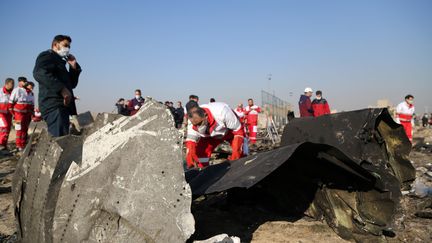 Les débris de l'avion sont inspectés, le 8 janvier 2020, après le crash du Boeing 737 de l'Ukrainian Airlines qui s'est écrasé près de l'aéroport de Téhéran, en Iran. (FATEMEH BAHRAMI / AFP)