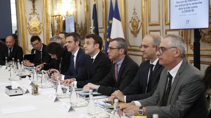 Le ministre de la Santé Olivier Veran, le président Emmanuel Macron et le secrétaire général de l'Elysée Alexis Kohler lors d'une réunion avec des chercheurs et des scientifiques sur l'épidémie de&nbsp;coronavirus le 5 mars 2020, à l'Elysée, à Paris.&nbsp; (YOAN VALAT / AFP)