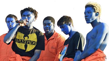 Les rappeurs du "boy band" Brockhampton, vêtus d'une combinaise de prisonnier orange, lors de leur prestation à Coachella en novembre 2017
 (KEVIN WINTER / GETTY IMAGES NORTH AMERICA / AFP)