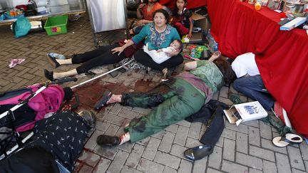 Des bless&eacute;s attendent l'arriv&eacute;e des secours au centre commercial Westgate de Nairobi vis&eacute; par une attaque terroriste le 22 septembre 2013. (GORAN TOMASEVIC / REUTERS)