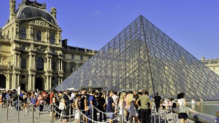 Des visiteurs font la queue devant la Pyramide du Louvre, le 11 décembre 2019.&nbsp; (TRIPELON-JARRY / AFP)