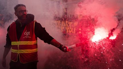 Un manifestant portant un gilet de la CGT avec un fumigène dans le cortège à Lyon (Rhône) vendredi 24 janvier 2020. (ROMAIN LAFABREGUE / AFP)