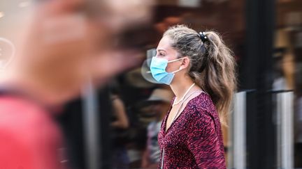 Une femme porte un masque dans la rue, à Lille, le 30 juillet 2020. (DENIS CHARLET / AFP)