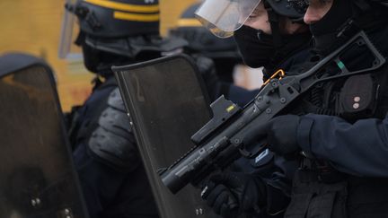 Un CRS tenant un lanceur de balles de défense (LBD), lors d'une manifestation à Nantes (Loire-Atlantique), le 17 décembre 2019. (LOIC VENANCE / AFP)