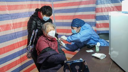 Une femme âgée se fait vacciner contre le Covid-19, le 15 décembre 2022 à Shanghai. (STR / AFP)