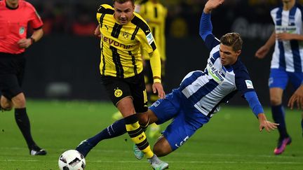 Le meneur de jeu du Borussia Dortmund, Mario Götze, évite ici le tacle du défenseur berlinois, Niklas Stark. (PATRIK STOLLARZ / AFP)