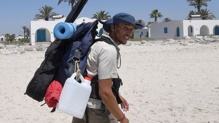 Certains gardiens privés surveillant les plages empêchent Mohamed Oussama de passer et exigent de le fouiller, le souvenir d'un assaillant arrivé avec un sac à dos et qui avait fait 38 morts sur une plage de Sousse en 2015 est encore vivace. Ce défenseur de la nature à l'allure athlétique est également en colère contre la réaction de certains estivants qui n'hésitent pas à lui demander de ramasser leurs déchets, le prenant pour leur «zabel» (éboueur en dialecte tunisien). Certaines nuits, Mohamed Oussama se voit néanmoins offrir le couvert et le confort d'un lit. Le reste du temps, il dort à la belle étoile, après s'être détendu en jouant de la guitare.
 (FETHI BELAID / AFP)