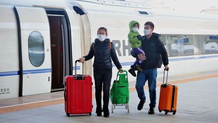 Une famille à la gare de Qingdao, dans l'est de la Chine, le 9 février 2020 (YU FANGPING / MAXPPP)