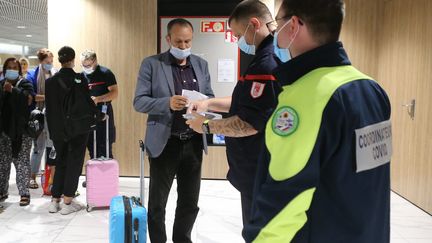 Les sapeurs-pompiers français contrôlent les pass sanitaires des passagers à l'euroairport de Bâle Mulhouse le 2 août 2021. (JEAN-FRANCOIS FREY / MAXPPP)