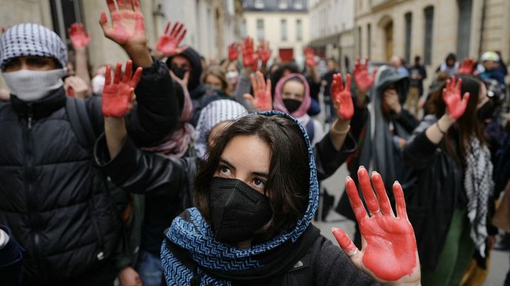 Pro-Palestinian demonstrators raise their red-painted hands in front of the Sciences Po Paris premises, April 26, 2024. (DIMITAR DILKOFF / AFP)