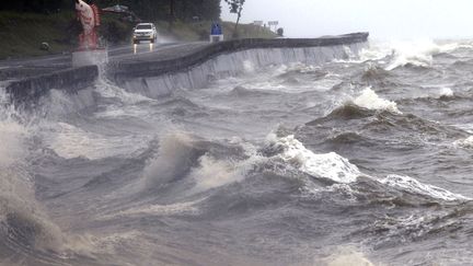 Une voiture passe pr&egrave;s d'une mer d&eacute;mont&eacute;e en raison du passage du typhon Hagupit &agrave; Atomonan (Philippines), le 8 d&eacute;cembre 2014. (ROMEO RANOCO / REUTERS)